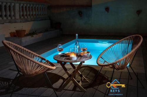 - une table et deux chaises à côté de la piscine dans l'établissement Maison Jade - Villa avec piscine - Barbecue - Calme, à Narbonne