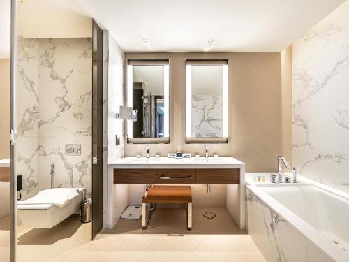 a bathroom with a sink and a tub and a toilet at SmartStay at Address Opera - Unique Burj Khalifa Views - Brand New Luxury Residences in Dubai