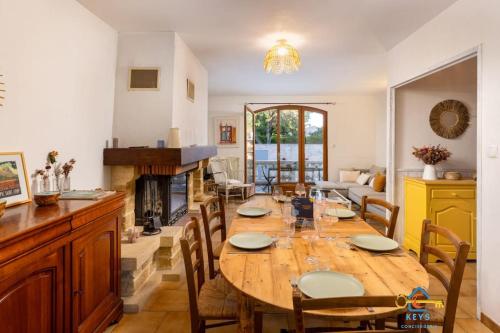une salle à manger avec une table et une cheminée dans l'établissement Maison Jade - Villa avec piscine - Barbecue - Calme, à Narbonne
