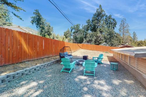 a backyard with green chairs and a fence at Honea Bee Hideout in Bass Lake Annex