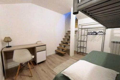 - une chambre avec un lit, un bureau et un escalier dans l'établissement Charmant Studio au cœur du centre historique, à Béziers