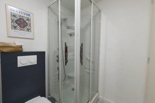 La salle de bains est pourvue d'une douche en verre et de toilettes. dans l'établissement Charmant Studio au cœur du centre historique, à Béziers