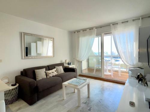 un salon avec un canapé et une table dans l'établissement PGH N37 - Vue Mer et Port, 8eme étage, Parking Privé, à La Grande Motte