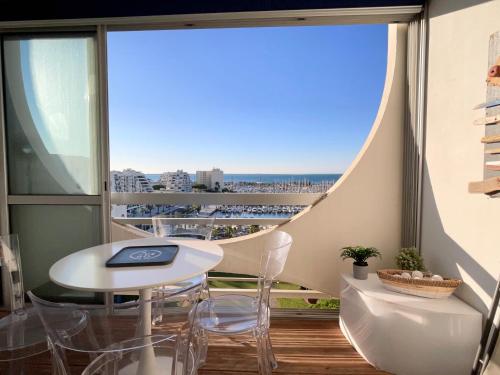 un balcon avec une table et des chaises et une vue sur l'océan dans l'établissement PGH N37 - Vue Mer et Port, 8eme étage, Parking Privé, à La Grande Motte