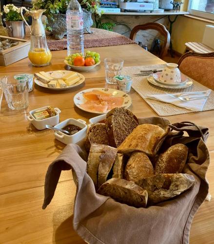 einen Tisch mit einem Korb Brot und anderen Lebensmitteln in der Unterkunft Casa la Rosa & Spa in Courdimanche-sur-Essonnes