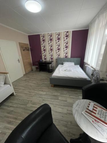 a bedroom with a bed and a couch and a table at Bequemes Zimmer in moderner Unterkunft My Pension Duisburg in Duisburg