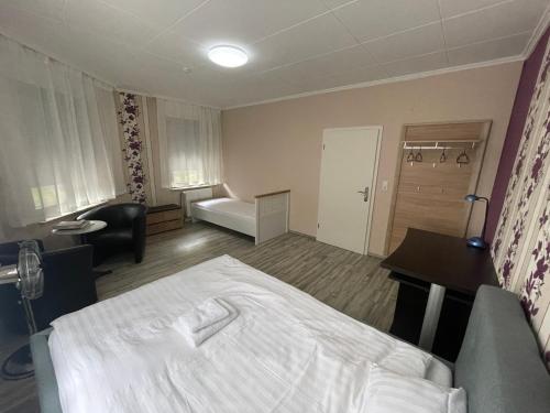 a hotel room with a bed and a desk at Bequemes Zimmer in moderner Unterkunft My Pension Duisburg in Duisburg