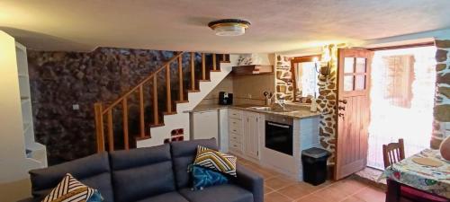 a living room with a couch and a staircase at Casas do Favacal in Penela