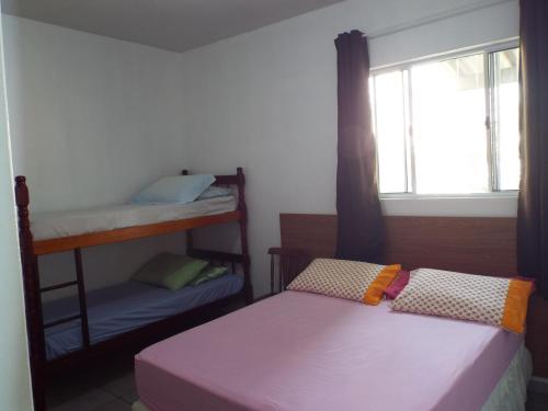 two bunk beds in a room with a window at Pousada Decarli Executiva Aeroporto Florianópolis in Florianópolis