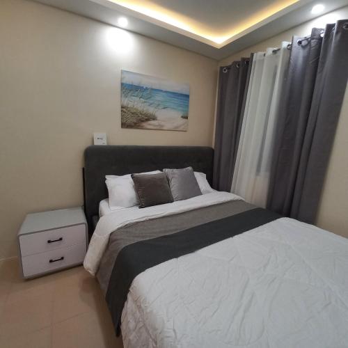 a bedroom with a large bed and a window at Khael's City Oasis at Marina Spatial in Dumaguete