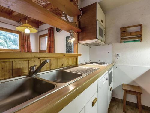 a kitchen with a stainless steel sink and wooden cabinets at Duplex spacieux avec terrasse, garage, et WIFI à Méribel - FR-1-355-7 in Méribel