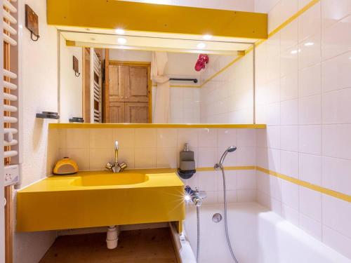 La salle de bains est pourvue d'un lavabo jaune et d'une douche. dans l'établissement Appartement 1 ch. confortable avec balcon et casier à skis à Méribel - FR-1-355-45, à Méribel