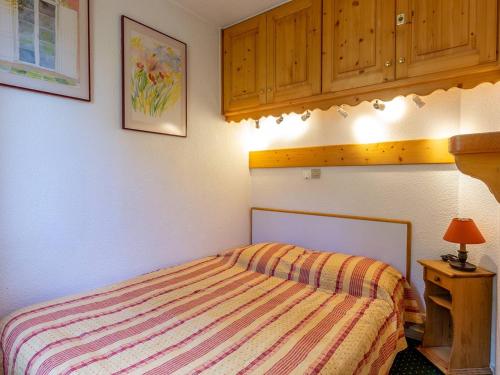 une chambre avec un lit et une armoire en bois dans l'établissement Appartement 1 ch. confortable avec balcon et casier à skis à Méribel - FR-1-355-45, à Méribel