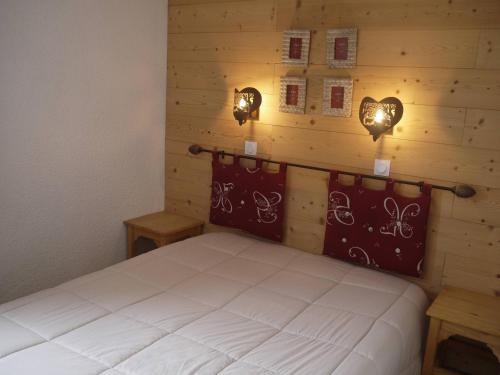 - une chambre avec un lit et deux lumières sur le mur dans l'établissement Charmant appartement à Méribel, 1 chambre, au pied des pistes, équipé et confortable - FR-1-355-32, à Méribel