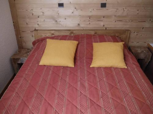 un lit avec deux oreillers dessus dans une chambre dans l'établissement Appartement au pied des pistes avec balcon et casier à ski, non-fumeur - FR-1-355-117, à Méribel