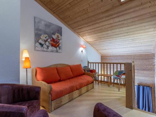 - un salon avec un canapé orange et un plafond en bois dans l'établissement Charmant duplex 8 pers. skis aux pieds à Méribel Mottaret, balcon, cuisine équipée, animaux admis - FR-1-355-141, à Méribel