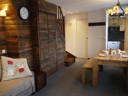 une chambre avec une table et une horloge sur un mur dans l'établissement Appartement 2 chambres avec mezzanine, piste skis aux pieds - FR-1-355-77, à Méribel