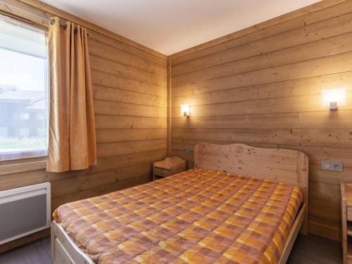 une chambre avec un lit avec des murs en bois et une fenêtre dans l'établissement Méribel Mottaret : Apt 2 ch, terrasse, accès piste, au cœur du quartier du Laitelet - FR-1-355-167, à Les Allues