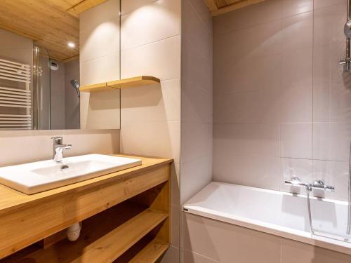 une salle de bain avec un lavabo et une baignoire dans l'établissement Méribel Mottaret : Apt 2 ch, terrasse, accès piste, au cœur du quartier du Laitelet - FR-1-355-167, à Les Allues