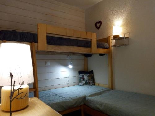 une chambre avec deux lits superposés et un bureau dans l'établissement Appartement Méribel au pied des pistes avec balcon, casier à skis et WIFI - FR-1-355-29, à Méribel
