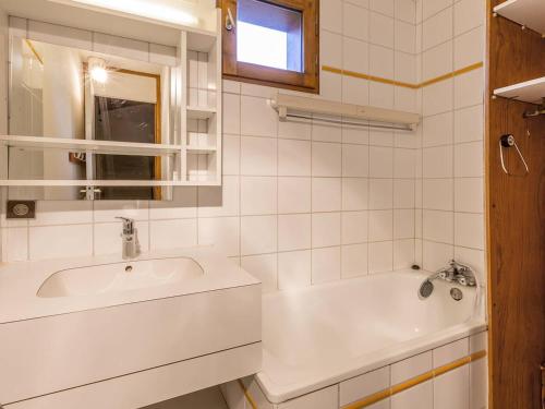 La salle de bains blanche est pourvue d'un lavabo et d'une baignoire. dans l'établissement Appartement spacieux 6 pers., balcon, casier à ski, au pied des pistes - FR-1-355-38, à Méribel