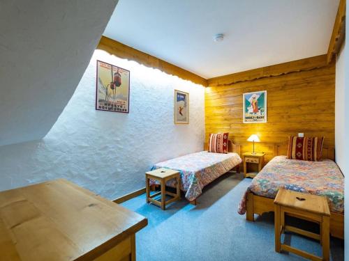 une chambre d'hôtel avec deux lits et une table dans l'établissement Appartement spacieux 6 pers., balcon, casier à ski, au pied des pistes - FR-1-355-38, à Méribel
