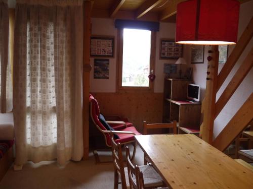 une salle à manger avec une table et des chaises et une fenêtre dans l'établissement Dupleix 2 chambres, balcon, proche pistes et commerces - FR-1-355-39, à Les Allues