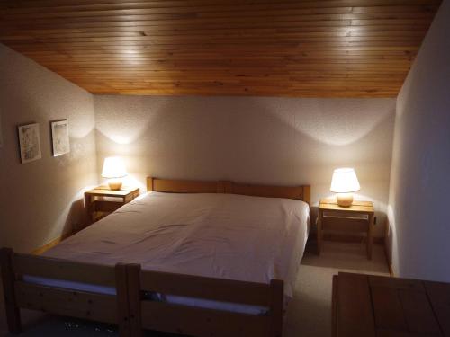 - une chambre avec un lit et deux lampes sur deux tables dans l'établissement Dupleix 2 chambres, balcon, proche pistes et commerces - FR-1-355-39, à Les Allues