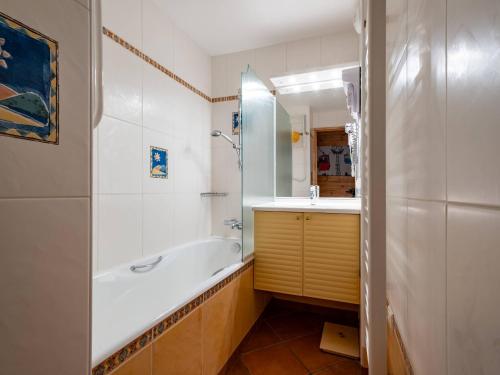 une salle de bain avec une baignoire, un lavabo et un miroir dans l'établissement Appartement 3 pièces Méribel Mottaret - 44m², pied des pistes, balcon, LABEL Méribel - FR-1-355-68, à Méribel