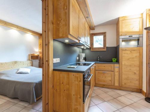 - une cuisine avec des placards en bois et un lit dans une chambre dans l'établissement Charmant appartement 3 chambres à Méribel, proche pistes et commerces - FR-1-355-200, à Les Allues