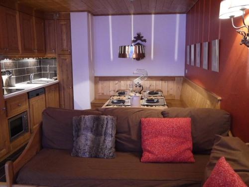 une cuisine avec un canapé en face d'une cuisinière dans l'établissement Bel appart T2 avec balcon proche pistes et commerces à Méribel - FR-1-355-70, à Méribel