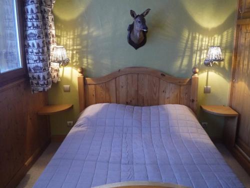 メリベルにあるBel appart T2 avec balcon proche pistes et commerces à Méribel - FR-1-355-70のベッドルーム1室(鹿の頭が壁に掛けられたベッド1台付)