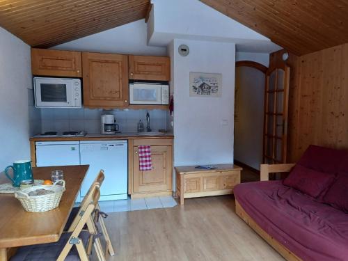 - une cuisine avec un canapé et une table dans une chambre dans l'établissement Appartement convivial à Méribel avec accès aux pistes et balcon - FR-1-355-75, à Méribel