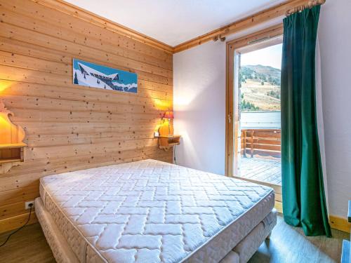 een slaapkamer met een bed en een groot raam bij Appartement familial - 2 chambres, balcon, proche pistes, Méribel - FR-1-355-96 in Méribel