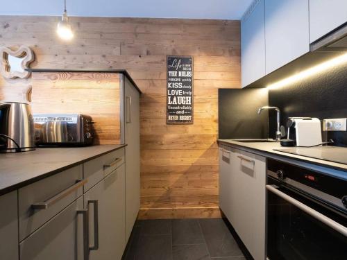 - une cuisine avec des murs en bois et un comptoir dans l'établissement Appartement lumineux avec balcon à Méribel, proche pistes et commerces - FR-1-355-128, à Méribel