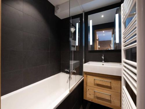 une salle de bain avec une baignoire blanche et un lavabo dans l'établissement Appartement lumineux avec balcon à Méribel, proche pistes et commerces - FR-1-355-128, à Méribel