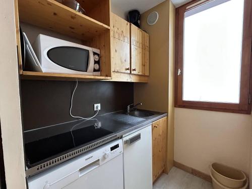 une petite cuisine avec un micro-ondes et un évier dans l'établissement Appartement rénové à Méribel, 1 chambre, 3 couchages, balcon, accès pistes, casier à skis, WIFI - FR-1-355-175, à Les Allues