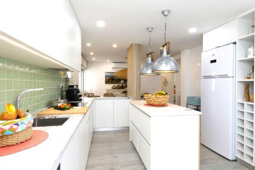 a kitchen with white cabinets and a counter top at Casa Titi-stunning Holiday Home With Private Pool in Tavira