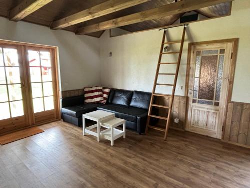 a living room with a black couch and a ladder at Matsi Maria Big in Matsi