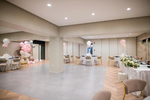 a banquet hall with tables and pink and white balloons at Hotel Epic Centrum in Cisnădie