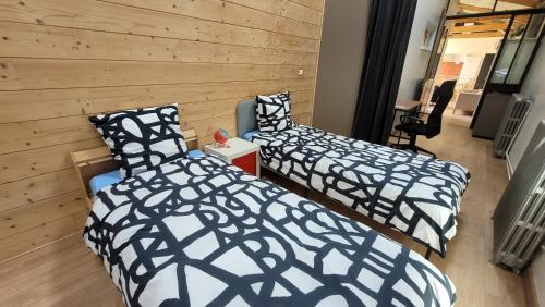 deux lits dans une chambre aux murs en bois dans l'établissement Loft 70 M2 Disney, à Fontenay-sous-Bois