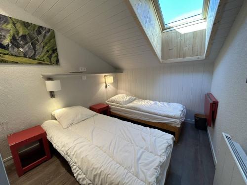 une petite chambre avec deux lits et une fenêtre dans l'établissement Appartement familial à Méribel, balcon, casier à skis, parking privatif - FR-1-355-237, à Les Allues