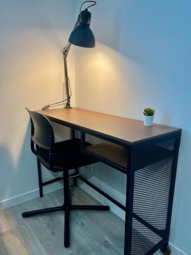 un bureau avec une chaise et une lampe. dans l'établissement Studio Terracotta - Futuroscope 20min - Rez de chaussée - tout équipé, à Châtellerault