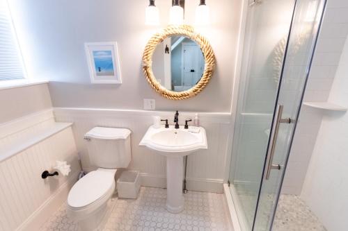 a bathroom with a toilet and a sink and a mirror at Paws on Pelham in Newport
