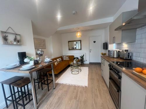 a kitchen and a living room with a couch at The Cosy Corner Leamington Spa, Warwick in Warwick