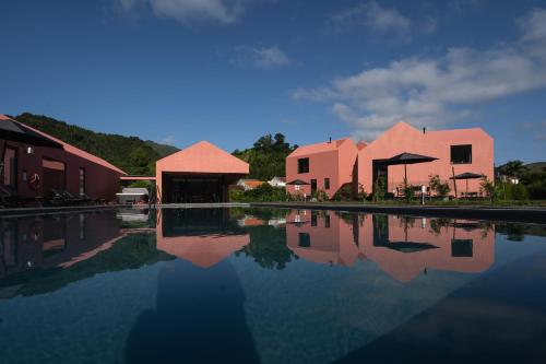 a group of buildings next to a pool of water at Canto`s Green Garden, Apartamentos Turísticos & SPA, 4 Estrelas in Furnas