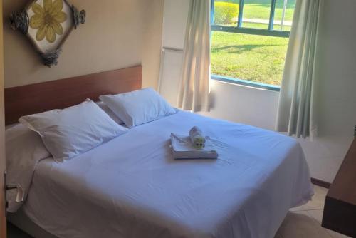 a bed with a book with a cat on it at Itu Garden - SPA e Resort Saudavel in Itu