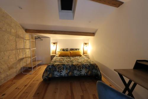 a bedroom with a bed and a table and chairs at Le duplex du 71 B in Niort
