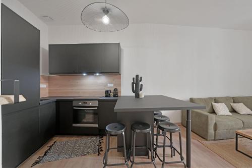 una cucina con tavolo e sgabelli in una stanza di Emile - Apt avec Clim intra muros ad Avignone