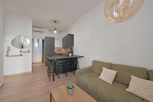 un salon et une cuisine avec un canapé et une table dans l'établissement Emile - Apt avec Clim intra muros, à Avignon